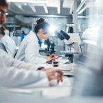 DNA Defense: Why Cancer Isn’t Beaten Yet Scientists working in a laboratory with microscopes and test tubes