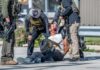 Police officers apprehending a suspect on the ground