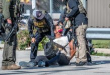 Police officers apprehending a suspect on the ground