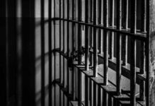 Close-up of prison bars casting shadows on a wall