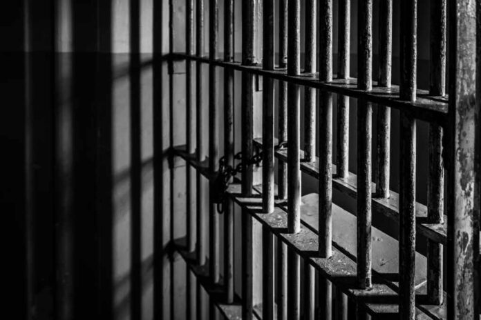Close-up of prison bars casting shadows on a wall