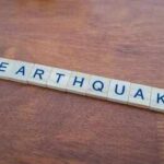 Scrabble tiles spelling earthquake on a wooden table