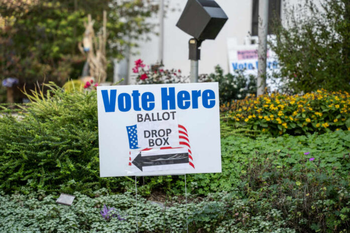 Sign indicating where to vote with a ballot drop box
