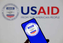 Smartphone displaying the USAID logo in front of a USAID backdrop