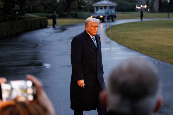 A political figure walking outdoors in formal attire during the evening