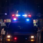 Graduation Chaos: Shots Rip Through Celebration Emergency vehicle with flashing lights in a busy urban area at night