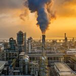 Moscow Refinery ERUPTS Near Kremlin An industrial oil refinery with smoke billowing from a stack at sunset