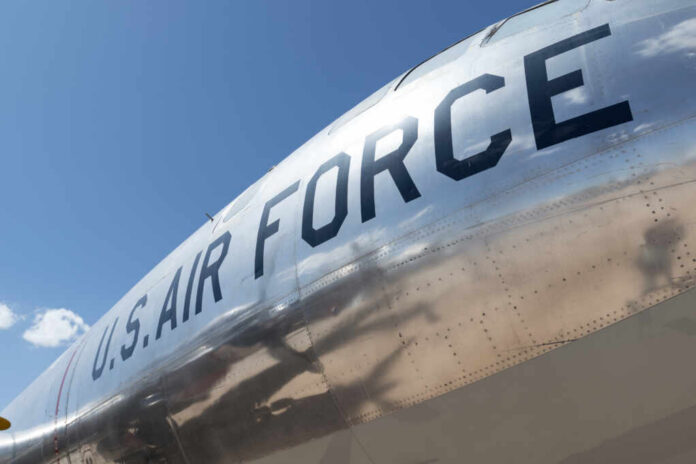 Close-up of a U.S. Air Force aircraft with a shiny metallic surface against a blue sky