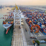 Aerial view of a busy shipping port with cargo containers and a large ship