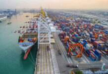 Aerial view of a busy shipping port with cargo containers and a large ship