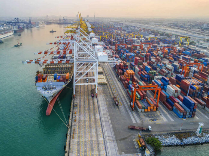 Aerial view of a busy shipping port with cargo containers and a large ship