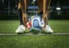 Soccer player placing a ball on a field