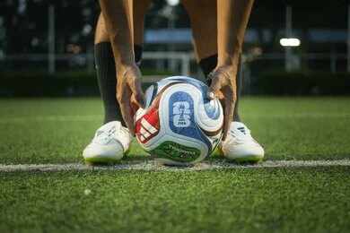 Soccer player placing a ball on a field