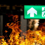 Bangkok Nightclub Horror, But Why Trapped? Green emergency exit sign with flames in the foreground