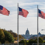 Three American flags waving in front of the Capitol building in Washington D.C.