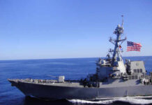 Hormuz Meltdown: Blockade, Missing Sailor, Blame Games A naval destroyer sailing in the ocean with an American flag