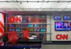 CNN newsroom set with red chairs and multiple TVs