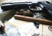 Terror Label Turns Drug War HOT Handgun with cash, pills, and marijuana on a table