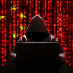 Foiled ISIS Plot Targets Jews In Maryland A hooded figure sitting in front of a laptop with a red digital background