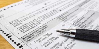 Ballot paper with pen on wooden surface