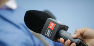 A hand holding a CNN microphone during a news interview