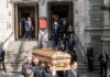 pallbearers carrying a casket down church steps