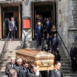 pallbearers carrying a casket down church steps