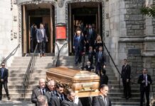 pallbearers carrying a casket down church steps