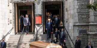 pallbearers carrying a casket down church steps