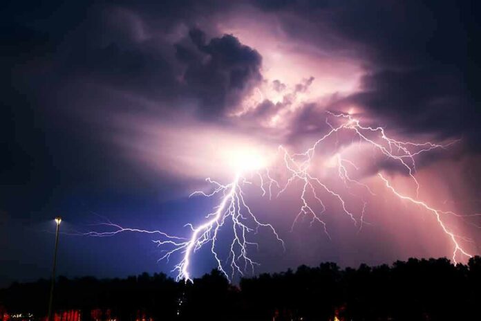 shutterstock_406163074 Lightning bolts illuminate storm clouds over a dark horizon