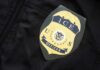 ICE officer badge on a dark uniform
