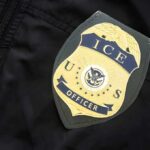 ICE officer badge on a dark uniform