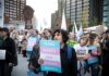 Protesters holding signs at a transgender rights rally