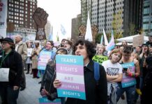 Protesters holding signs at a transgender rights rally