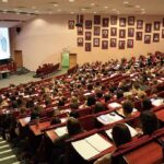 Students seated in a lecture hall listening to a presentation