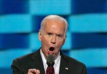 man in suit speaking passionately at a podium
