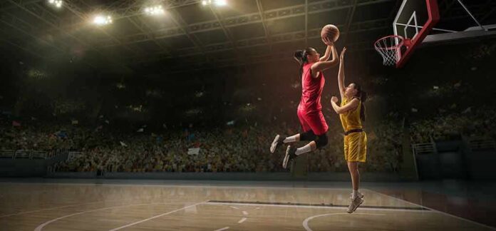 Two basketball players contest a layup under the hoop