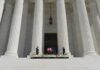 Congress Targets Reporter Over Iran Trip Flag-draped casket on courthouse steps between towering columns