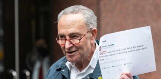 man in FEMA jacket holding a printed tweet