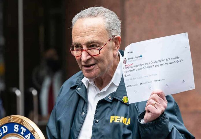 man in FEMA jacket holding a printed tweet