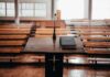 Podium with microphone and book in empty lecture hall