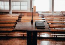 Podium with microphone and book in empty lecture hall
