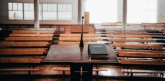 Podium with microphone and book in empty lecture hall