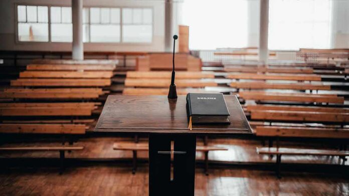 Podium with microphone and book in empty lecture hall
