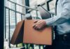 Office worker carrying a cardboard box of belongings