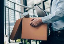 Office worker carrying a cardboard box of belongings