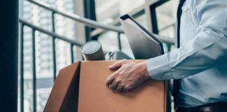 Office worker carrying a cardboard box of belongings