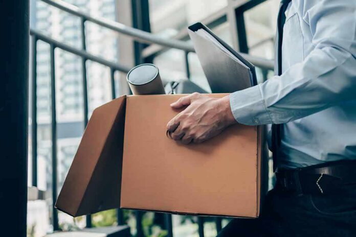 Office worker carrying a cardboard box of belongings