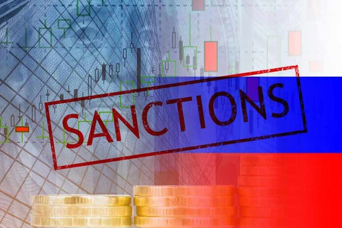 Sanctions text over financial chart and flag with coin stacks