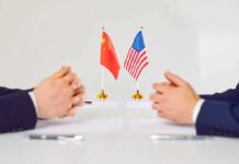 Rubio’s Stark Warning On China Ties Two diplomats sit across table with China and United States flags between them